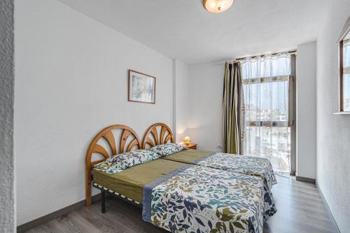 ein Schlafzimmer mit einem Bett und einem Fenster in der Unterkunft Family flat with 3 bedrooms and balcony near Los Gigantes and ocean in Puerto de Santiago