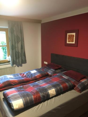 a bed with a plaid blanket on it in a bedroom at Appartments Haus Rettenmoser in Mittersill