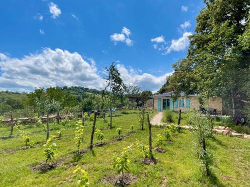 a garden with trees in front of a house at La Belle Petite Ferme Rosiers de Julliac 19350 in Les Bos
