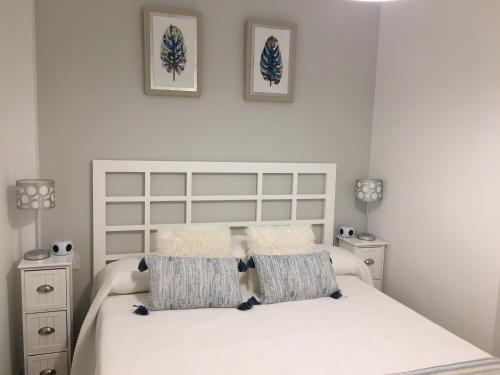 1 dormitorio con 1 cama blanca y 2 mesitas de noche en GARDEN - TURIS PLUS Apartamentos, en Benidorm