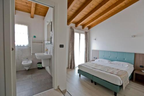 een slaapkamer met een groot bed en een badkamer bij Hotel Lago di Como in Colico