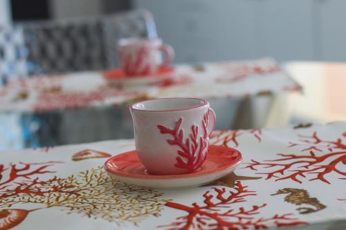 a red cup and a saucer on a table at Las Floridas Apartment in Alghero
