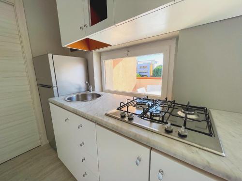 a small kitchen with a stove and a sink at Las Floridas Apartment in Alghero
