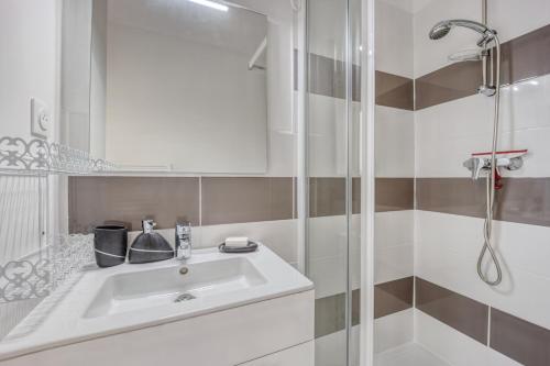 La salle de bains est pourvue d'un lavabo et d'une douche. dans l'établissement Le Petit Normand, à Courseulles-sur-Mer