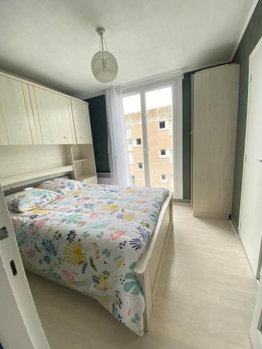 a bedroom with a bed with a floral comforter at Détente en plein coeur du Tréport ! in Le Tréport