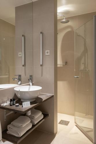 a bathroom with a sink and a glass shower at Elite Hotel Ideon, Lund in Lund