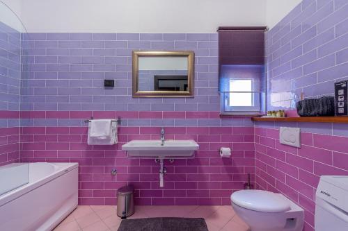 Fioletowa łazienka z umywalką i toaletą w obiekcie Apartment Maris w Rovinj