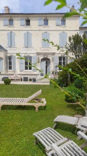 two benches in front of a large building at Le Jardin des Anges in Saint-Jean-dʼAngély