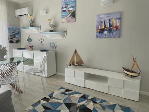 a living room with a white cabinet with a boat on it at Las Floridas Apartment in Alghero