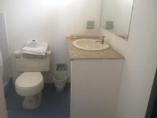 a bathroom with a white toilet and a sink at Hotel Aguablanca in La Mesa