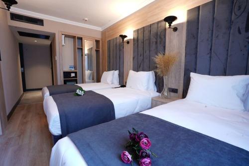 a hotel room with two beds with roses on them at Mineo Hotel Taksim in Istanbul
