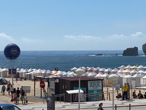 a beach with a bunch of umbrellas and the ocean at BayView Nazaré in Nazaré