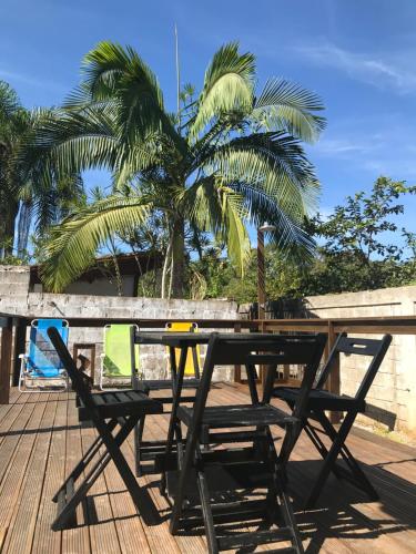a picnic table with two chairs and a palm tree at Farol da Barra Seca Ubatuba in Ubatuba