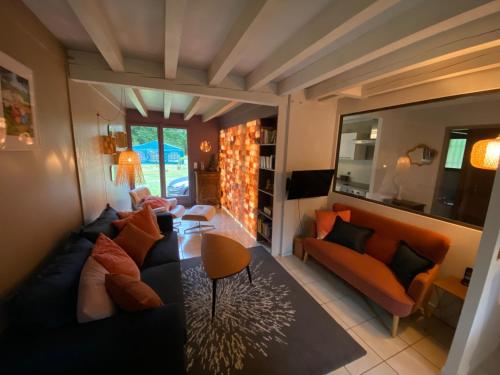 a living room with a couch and a table at Spa et détente au cœur de la forêt des Landes - 3 étoiles in Luglon