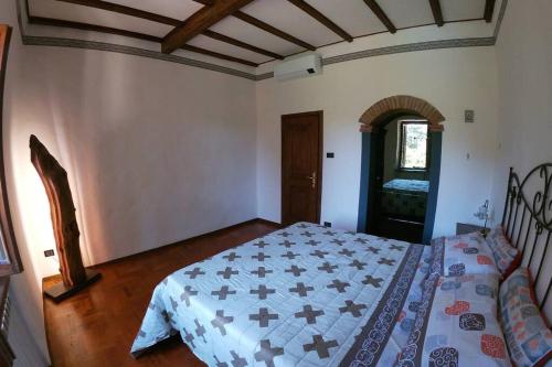 a bedroom with a bed with a blue and white quilt at La Menchina ( Alloggio privato) in Arezzo
