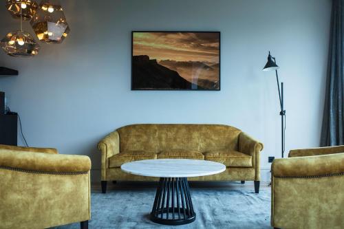 a living room with a couch and a table at Hôtel L'Incomparable Aix-Les-Bains in Tresserves