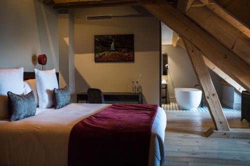 a bedroom with a large bed and a bathroom at Hôtel L'Incomparable Aix-Les-Bains in Tresserves