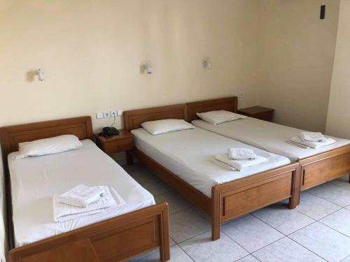 two twin beds in a room with towels on them at Olympic Beach Hotel in Nei Poroi