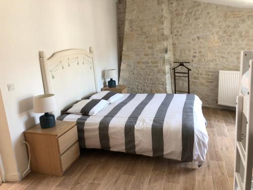 une chambre avec un lit et un mur de briques dans l'établissement Maison de charme LA ROCHELLE ILE DE RE, à Dompierre-sur-Mer