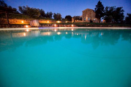 a large pool of water with a building in the background at Fattoria Le Fonti in Poggibonsi