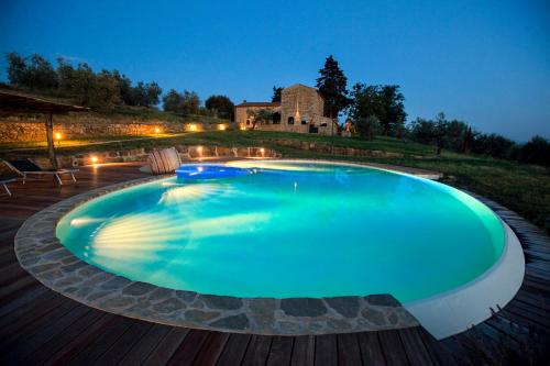 a large swimming pool in a backyard at night at Fattoria Le Fonti in Poggibonsi