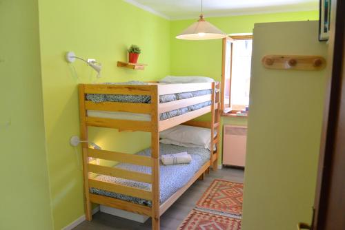 a small room with two bunk beds and a kitchen at House La Motta by Holiday World in Borgata Sestriere