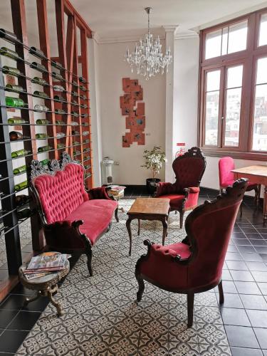 a living room with red furniture and a chandelier at Casa Puente Hotel Boutique in Valparaíso