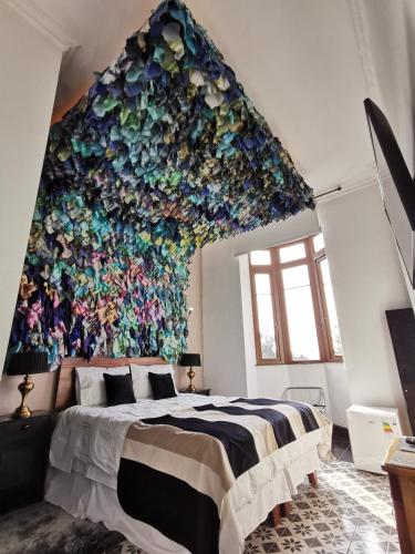 a bedroom with a large wall of flowers at Casa Puente Hotel Boutique in Valparaíso