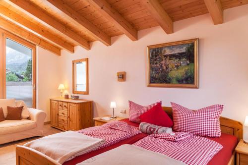 um quarto com uma cama com almofadas vermelhas e brancas em Das Bergzeit em Farchant