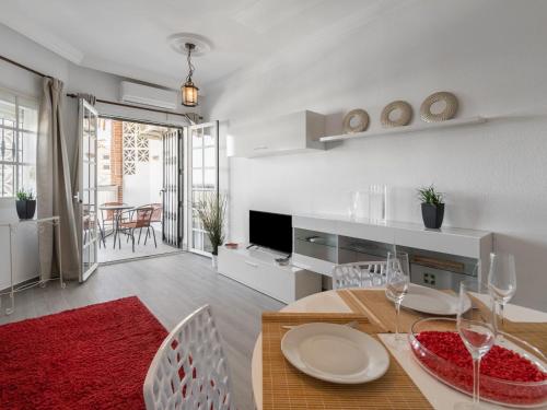 a living room with a table and chairs and a television at Apartment Pueblo Quinta-3 by Interhome in Benalmádena