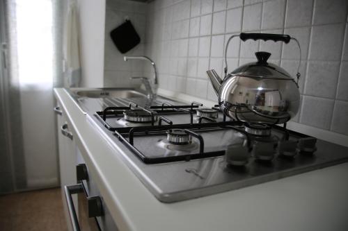 a tea kettle sitting on top of a stove in a kitchen at Home & Breakfast La Madonnina 013136-CNI-00001 in Lurago D'Erba 