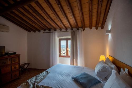 a bedroom with a large bed and a window at Estalagem de Monsaraz in Monsaraz