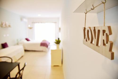 a living room with a love sign hanging on a wall at Luminosos y modernos departamentos en Rosario in Rosario