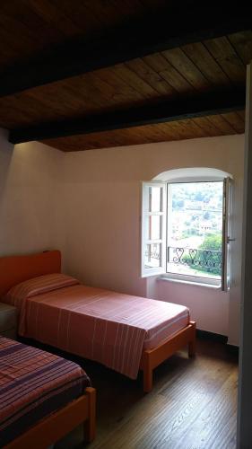 two beds in a room with a window at La Torretta in Beverino
