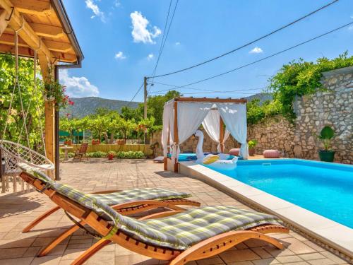 a villa with a pool and a hammock next to a house at Holiday Home Villa Anđelika by Interhome in Drivenik