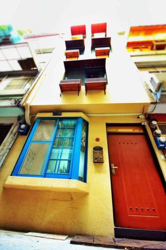 a building with a red door and two chairs on it at 高雄市包棟民宿-高雄寵物友善民宿-高雄阿爾兔兔民宿-Rabbit house in Kaohsiung