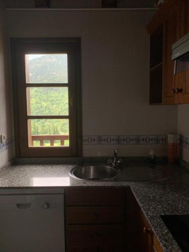 a kitchen counter with a sink and a window at Casa Planominguero in Taull