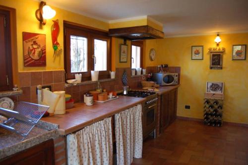 a kitchen with yellow walls and a counter top at Casa intera tra le colline e le vigne del Dolcetto in Rocca Grimalda