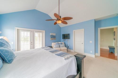 a blue bedroom with a bed and a ceiling fan at Inlet Blue Home in Inlet Beach