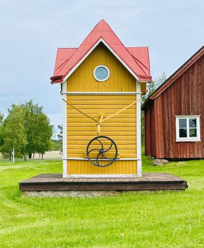 a wooden outhouse with a large wheel on it at Eleonora Bed & Breakfast in Kristiinankaupunki