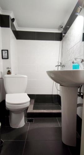 a bathroom with a white toilet and a sink at Nearby the sea in Asprovalta