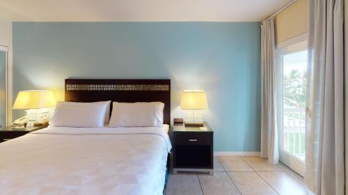 a bedroom with a large white bed and a window at Holiday Inn Resort Grand Cayman by IHG in George Town