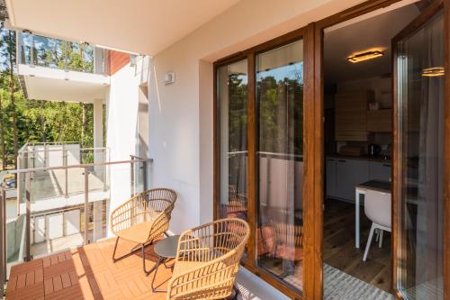 a balcony of a house with chairs and a table at APARTAMENTY MIERZEJA - STEGNA PARK STUDIO, 500 m od plaży, bezpłatny meleks in Stegna
