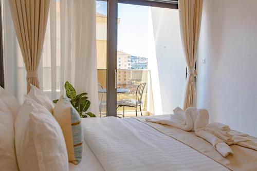 a white bed with a view of a balcony at Delightful Studio Soho City in Bar