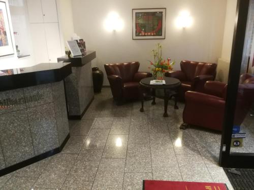a waiting room with leather chairs and a table at Hotel An der Philharmonie in Cologne