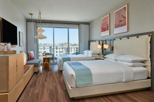 a hotel room with two beds and a television at Mission Pacific Beach Resort, part of JdV by Hyatt in Oceanside