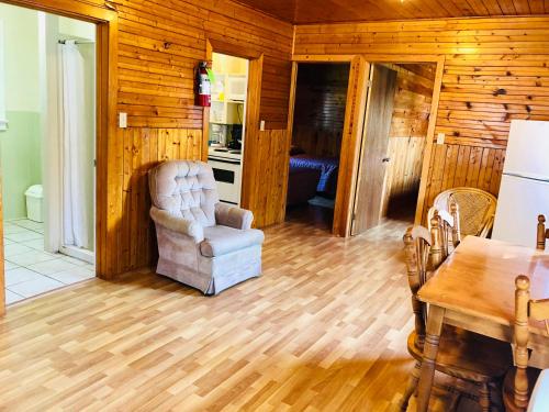 a living room with a chair and a table at Green Gables Bungalow Court in Cavendish
