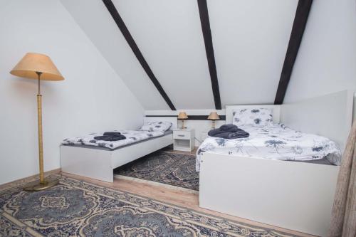 a room with two beds and a lamp and a rug at Apartman Jozefina in Netretić