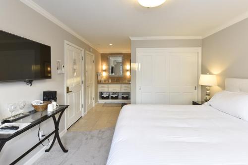 a bedroom with a large white bed and a television at 683 Cottages at Silverado residence in Napa
