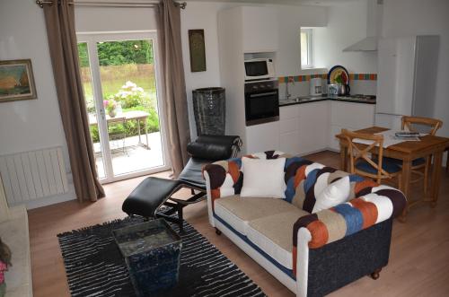 un salon avec un canapé et une cuisine dans l'établissement Les terrasses de l'artiste, à Bazenville